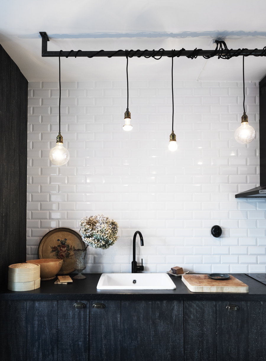 Stained black Ikea cabinets contrast with the white subway tile. Photograph by Anna Kern for Skona Hem.